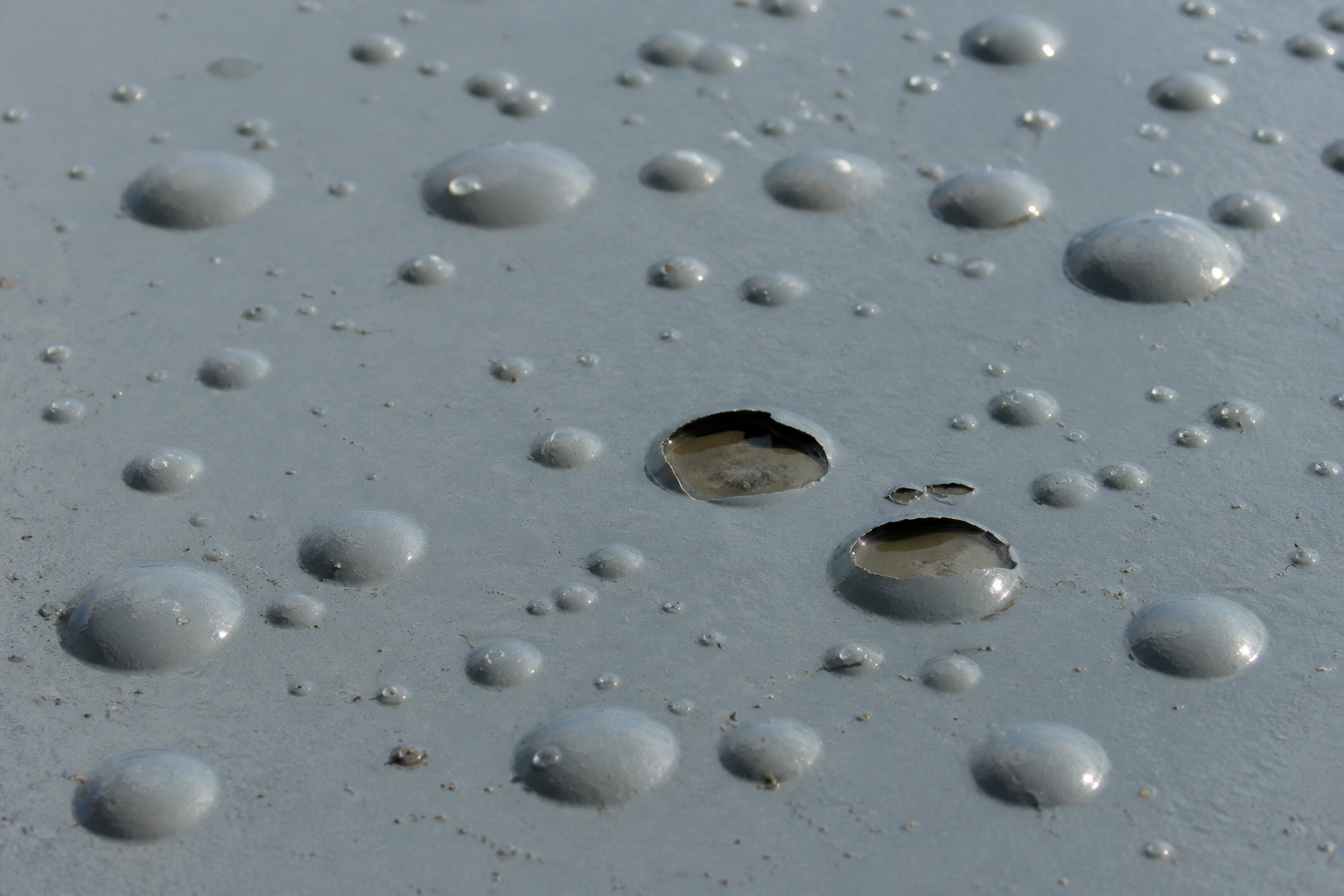 Photorealistic illustrative reference showing blistering on a protective coating system