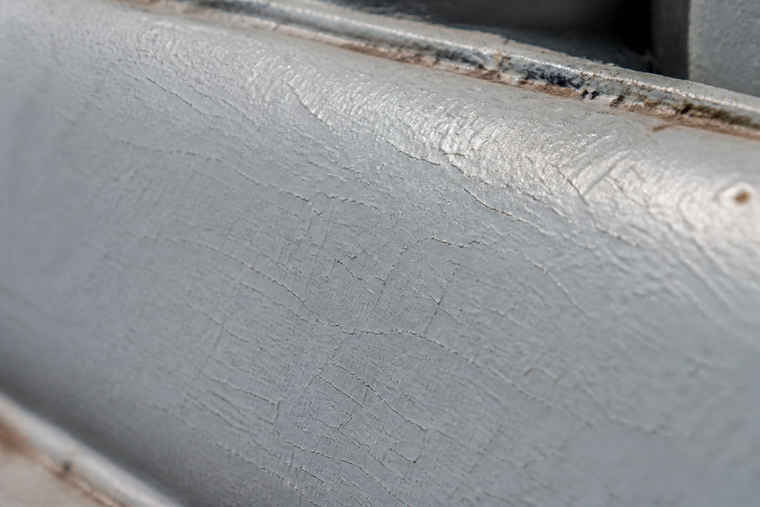 Photorealistic illustrative reference showing checking on a protective coating system