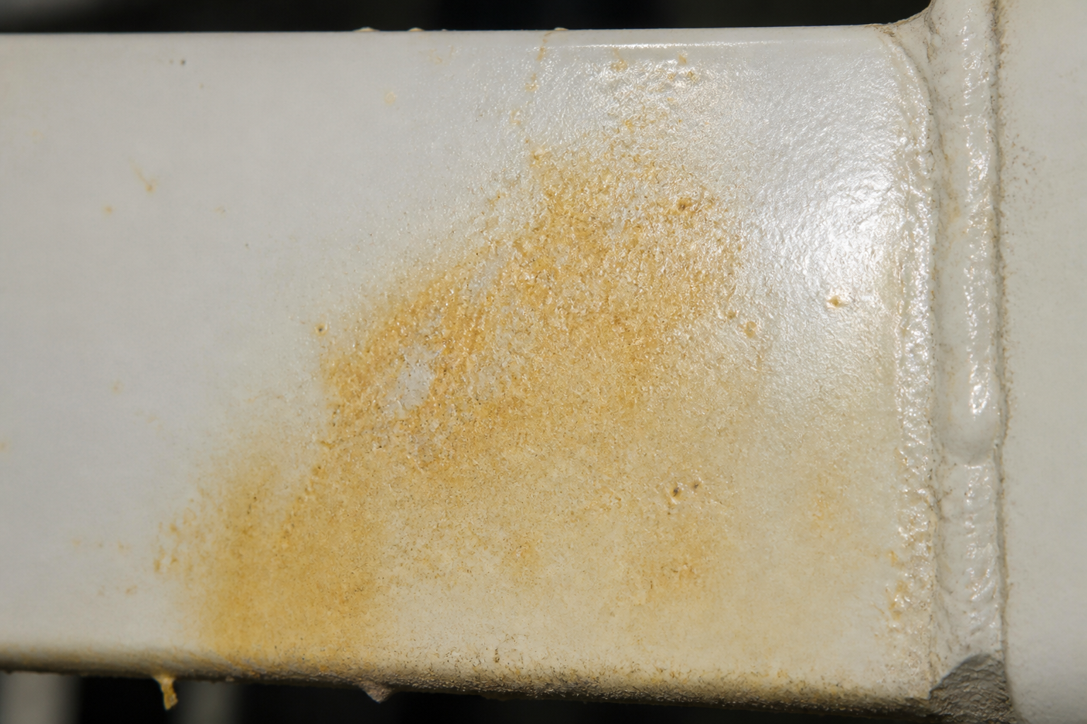 Photorealistic illustrative reference showing discoloration on a protective coating system