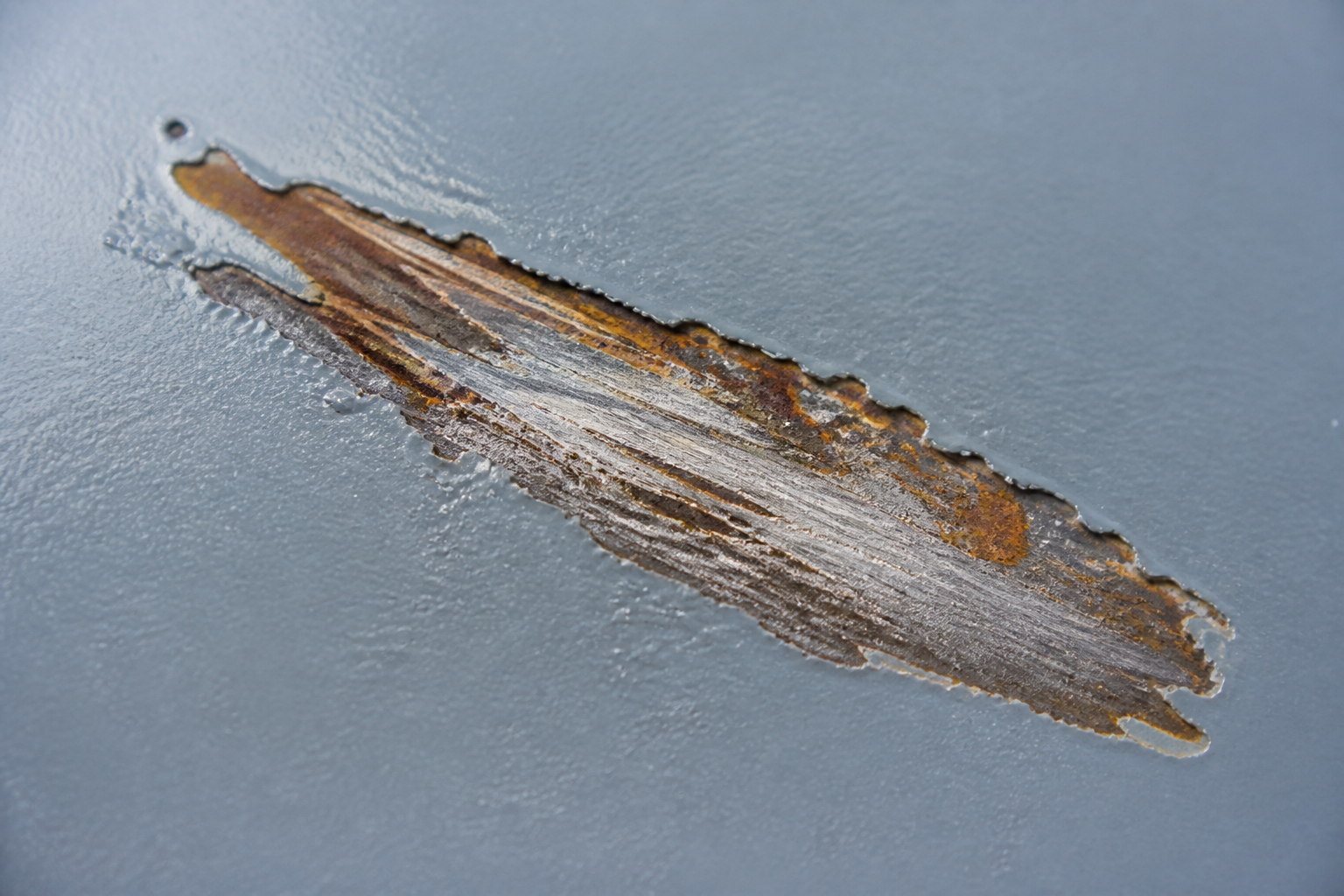 Photorealistic illustrative reference showing mechanical damage on a protective coating system