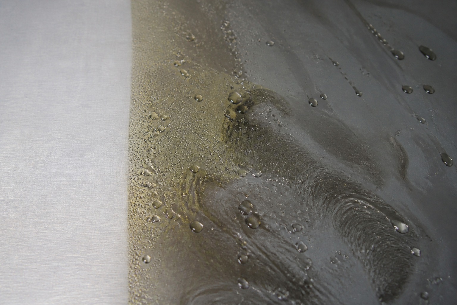 Photorealistic illustrative reference showing oil / grease contamination on a protective coating system