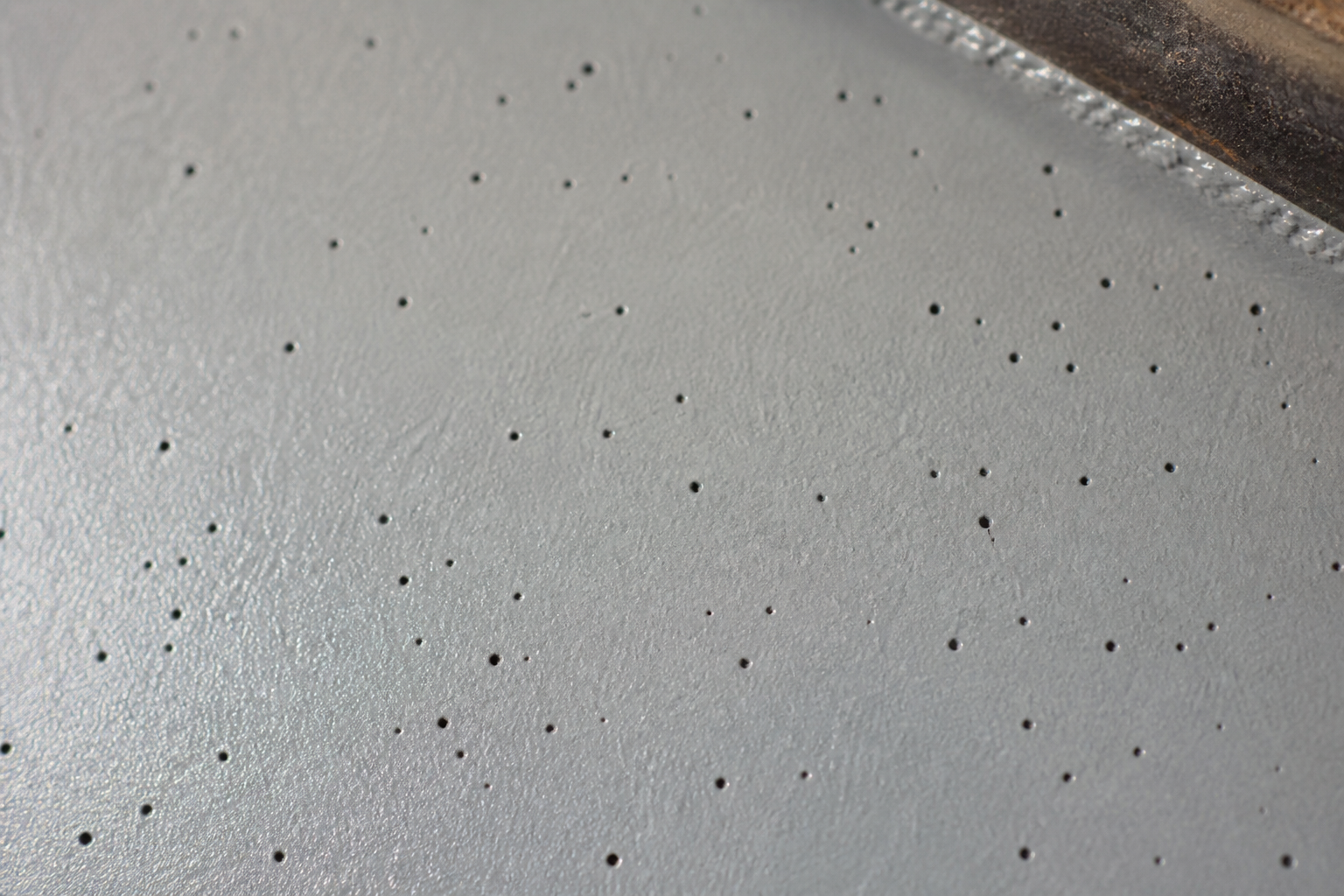 Photorealistic illustrative reference showing pinholing on a protective coating system
