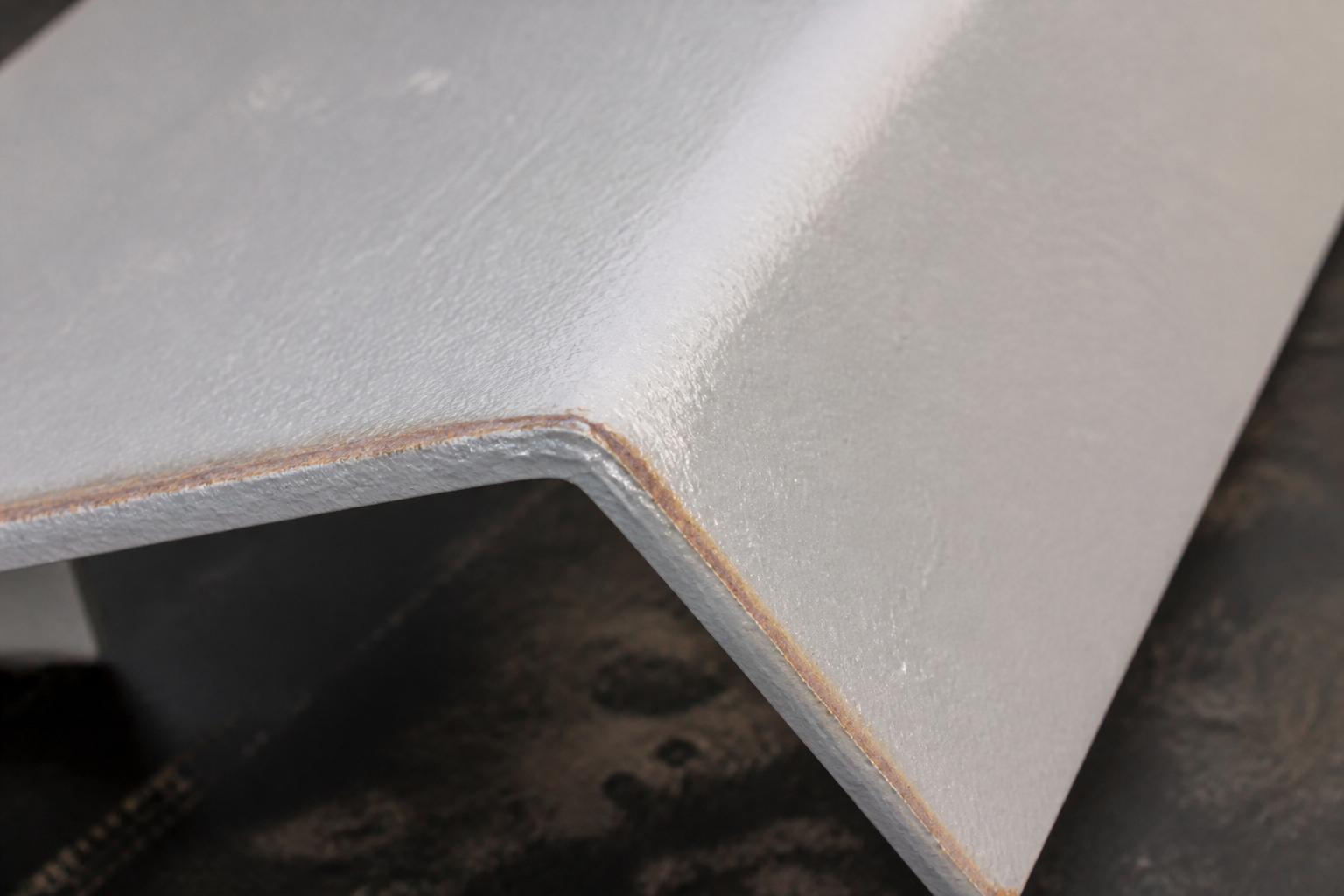 Photorealistic illustrative reference showing poor edge coverage on a protective coating system