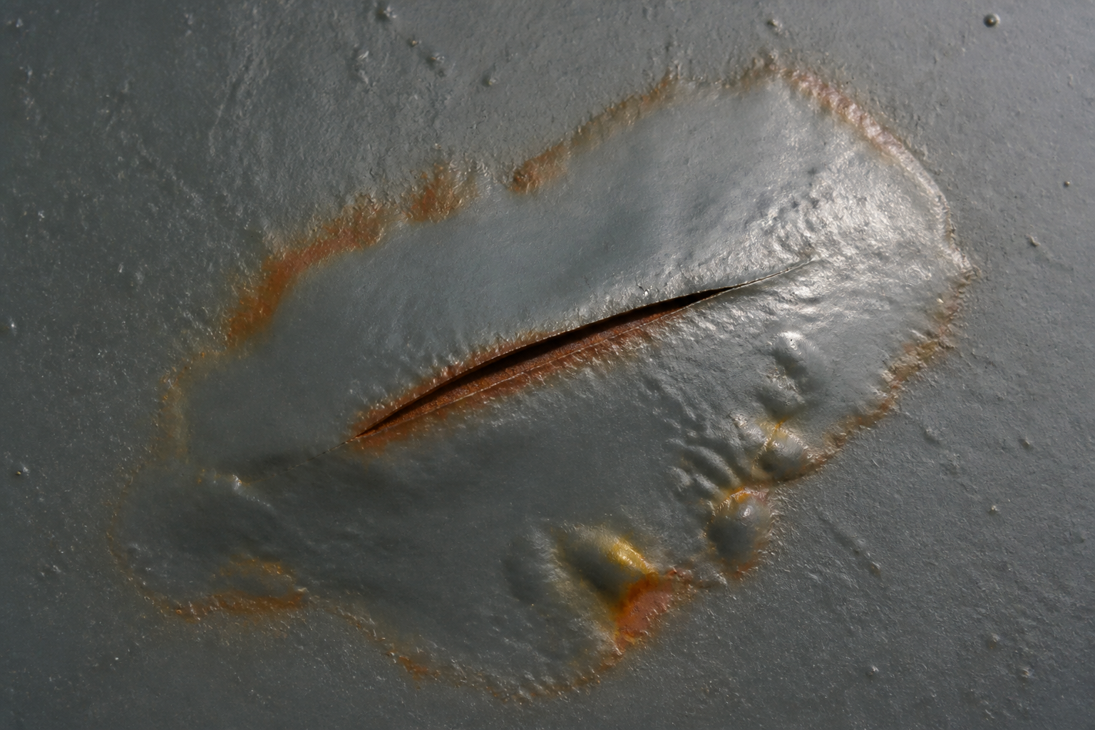 Photorealistic illustrative reference showing underfilm corrosion on a protective coating system